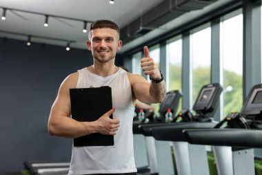 Spor merkezinde parmak gösterme panosu olan kişisel antrenör