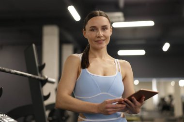 Spor salonunda tableti olan profesyonel kişisel antrenör.