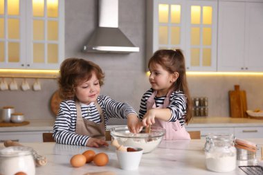 Yemek tarifi. Sevimli çocuklar mutfaktaki masada kurabiye için para kazanıyor.