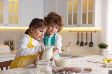 Yemek tarifi. Sevimli çocuklar mutfaktaki masada kurabiye için para kazanıyor.