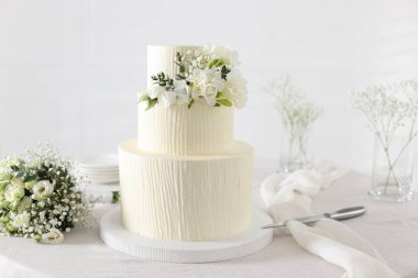 Çiçekli düğün pastası ve kapalı masa desenli lezzetli bir pasta.