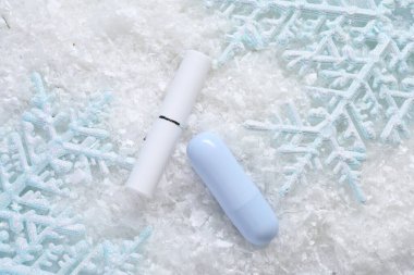 Nemlendirici dudak kremi ve yapay karla süslenmiş Noel süsü. Kış bakımı