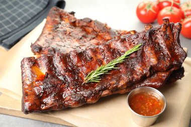 Biberiyeli, domatesli ve açık gri masadaki soslu domuz pirzolası. Yakın plan.