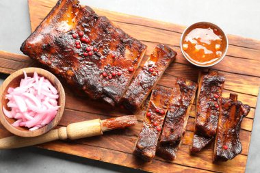 Lezzetli kaburgalar, sos, soğan ve fırça gri masada, üst manzara