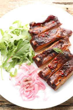 Lezzetli domuz pirzolası, roka ve soğan ahşap masa, üst manzara.