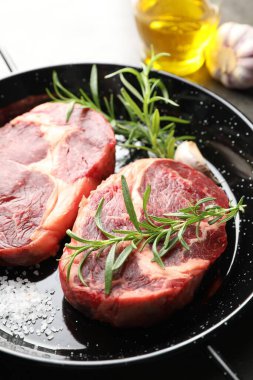 Yemek masasında çiğ et ve baharat parçaları, yakın plan.