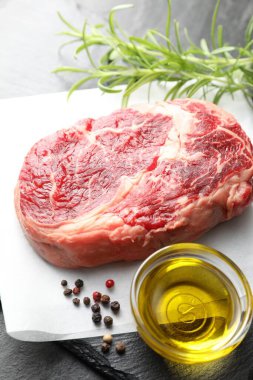 Masanın üstünde çiğ et ve baharat var.