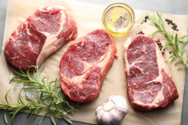 Çiğ et parçaları ve baharatlar gri masada, düz yatıyordu.