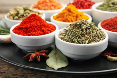 Ahşap masada farklı aromatik baharatlar, yakın plan.