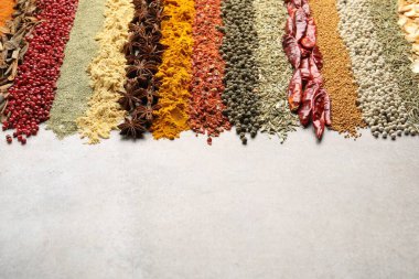 Açık gri masada birçok farklı baharat var, yakın plan. Metin için boşluk