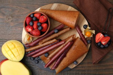 Lezzetli meyve dürümleri, mango ve böğürtlenler ahşap masada, düz yatıyordu.