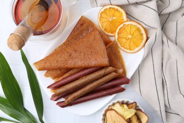 Lezzetli meyve dürümleri ve portakal dilimleri beyaz masada, düz yatıyordu.