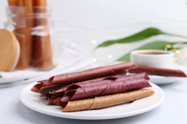 Lezzetli meyveler beyaz masada yuvarlanıyor.