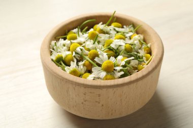 Kase içinde taze papatya çiçekleri açık ahşap masada, yakın plan