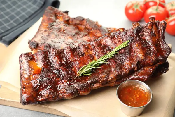 Biberiyeli, domatesli ve açık gri masadaki soslu domuz pirzolası. Yakın plan.