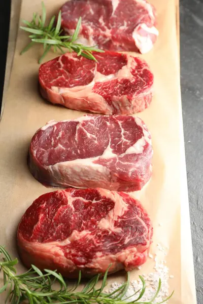 Çiğ et parçaları, biberiye ve tuz masanın üstünde.