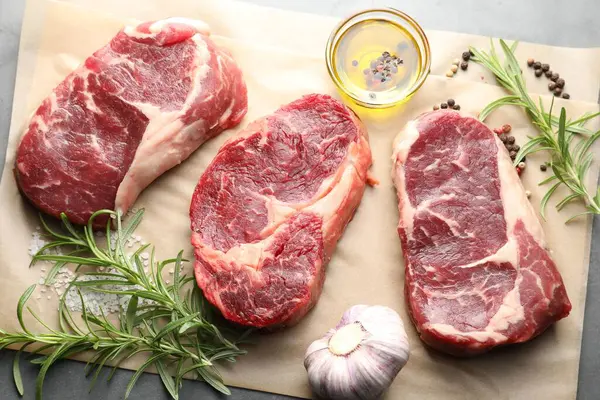 Çiğ et parçaları ve baharatlar gri masada, düz yatıyordu.