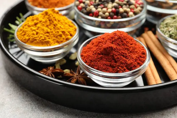 Açık gri masada farklı aromatik baharatlar, yakın plan.