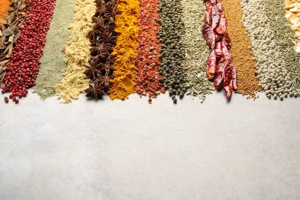 Açık gri masada birçok farklı baharat var, yakın plan. Metin için boşluk