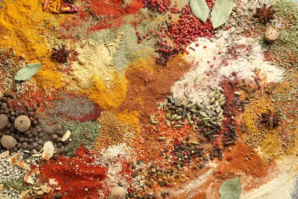 Gri masada farklı aromatik baharatlar, üst görünüm.