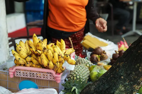 Markette değişik egzotik meyveler satan bir kadın, yakın plan.