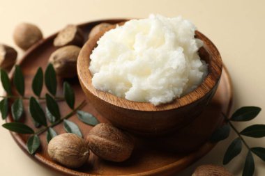 Tereyağı, fındık ve yapraklar bej arka planda, yakın plan