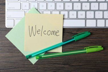 Kağıt nota kelime ile Hoşgeldiniz, kalem ve klavye ahşap masa, düz yatıyordu