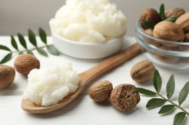 Beyaz ahşap masada doğal Shea yağı, yakın plan.