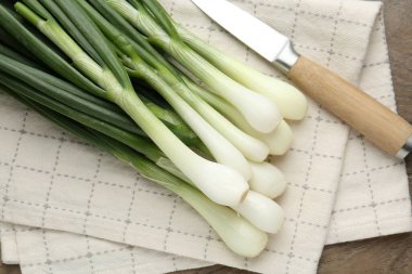 Taze taze soğan ve bıçak ahşap masada, düz yatıyordu.