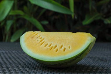 Dışarıdaki hasır masada leziz bir karpuz dilimi, yakın plan.