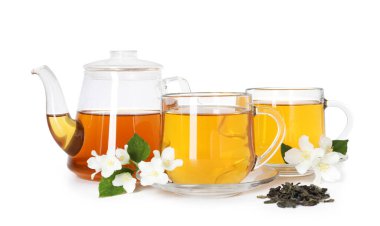 Cam fincanlarda, çaydanlıkta, çiçeklerde ve yapraklarda beyazda izole edilmiş yasemin çayı.