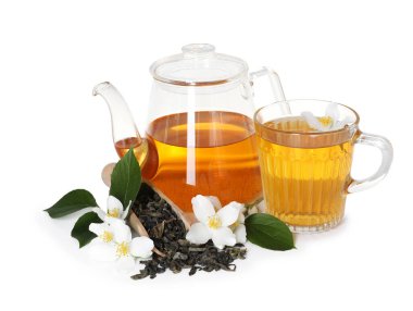 Aromatik yasemin çayı, cam bardak, çaydanlık, çiçekler ve kuru yapraklar beyaz üzerine izole edilmiş.