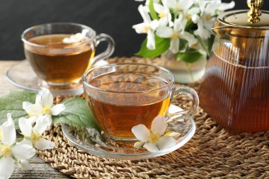 Cam fincanlarda, çiçeklerde ve çaydanlıkta Aromatik yasemin çayı, yakın plan