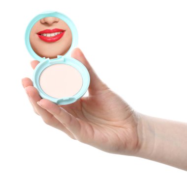 Kırmızı dudaklı güzel kadın beyaz arka planda pudra aynasına bakıyor, yakın plan.