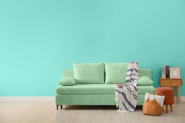 Rahat kanepesi ve turkuaz duvarı olan şık bir oturma odası. İç tasarım