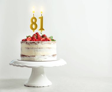 Meyveli lezzetli pasta ve beyaz arka planda yanan mumlar, yazı için yer. 81. yaş günü veya diğer özel günler