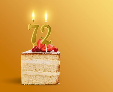 Altın renkli arka planda mum şeklinde yanan bir parça kek, yazı için yer. 72. Doğum günü veya diğer özel günler