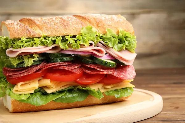 Tahta masada jambonlu ve sebzeli baget sandviç, yakın plan.