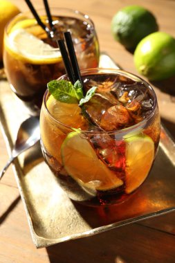 Küba libre kokteylini ahşap masada nane şekeri ile tazeliyorum.
