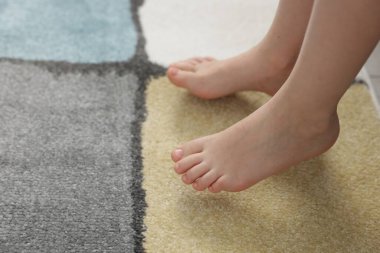 Evdeki yumuşak halıdaki kız, yakın plan.