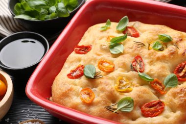 Yemek masasında domates ve baharatlarla nefis bir Focaccia, yakın plan.