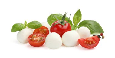 Lezzetli mozzarella peyniri topları, domatesler, biberler ve beyaz üzerine izole edilmiş fesleğenler.