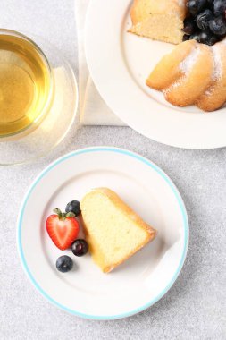 Pudra şekeri, böğürtlen ve çay ile açık gri masada, düz bir şekilde yatıyordu.