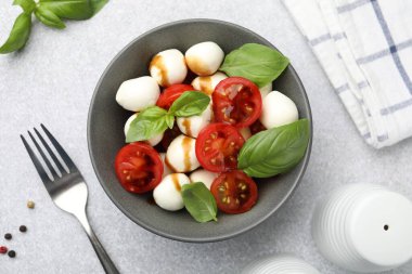 Peynirli salata, domates ve fesleğen. Masada servis ediliyor.