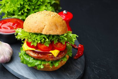Siyah masada servis edilen köfteli lezzetli hamburger, yakın plan. Metin için boşluk