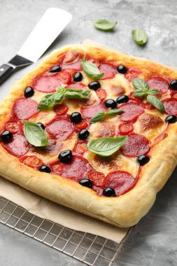 Gri masada ev yapımı pizza ve sunucu, yakın plan.