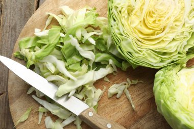 Ahşap masada lahana ve bıçak kes, düz yat.