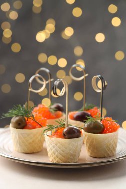 Bulanık ışıklara karşı beyaz masadaki lezzetli kanepeler.