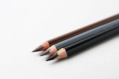 Arka planda üç farklı kaş kalemi, yakın plan. Metin için boşluk