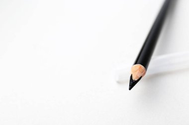 Açık arkaplanda siyah kaş kalemi, yakın plan. Metin için boşluk